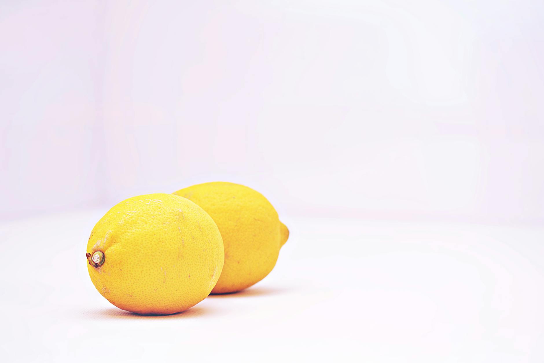Two fresh lemons on a white background, representing the lemon vibrator design concept