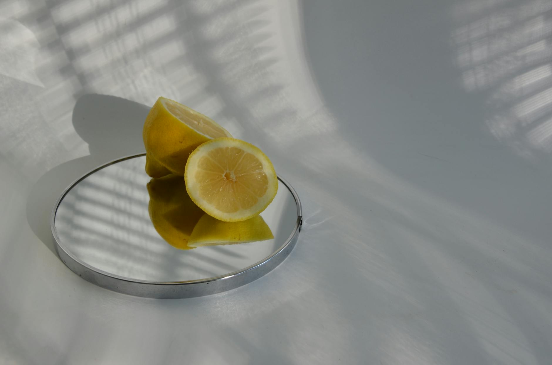 A hand holding a blue clitoral vibrator above a decorative glass bowl