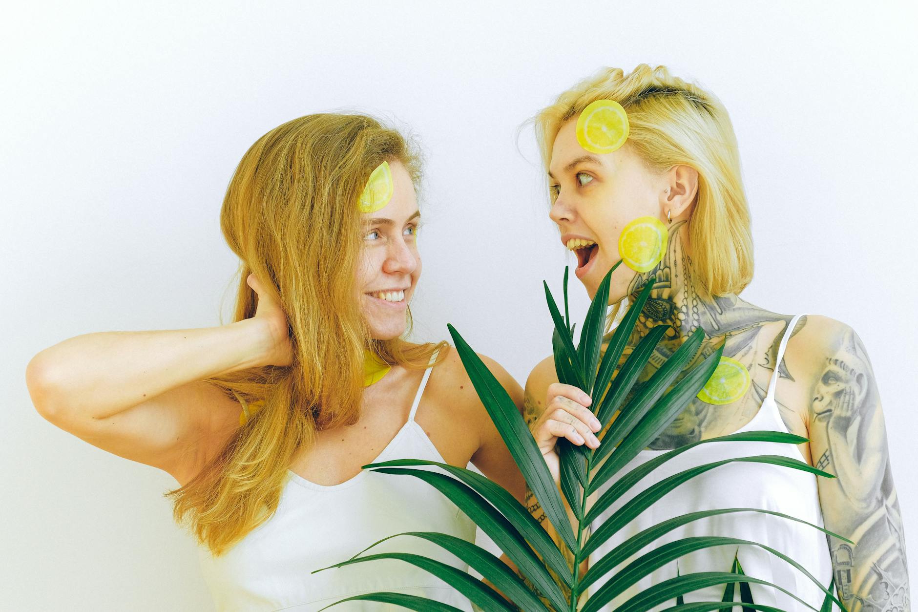 Two women smiling with fresh lemons, expressing joy and confidence in midlife