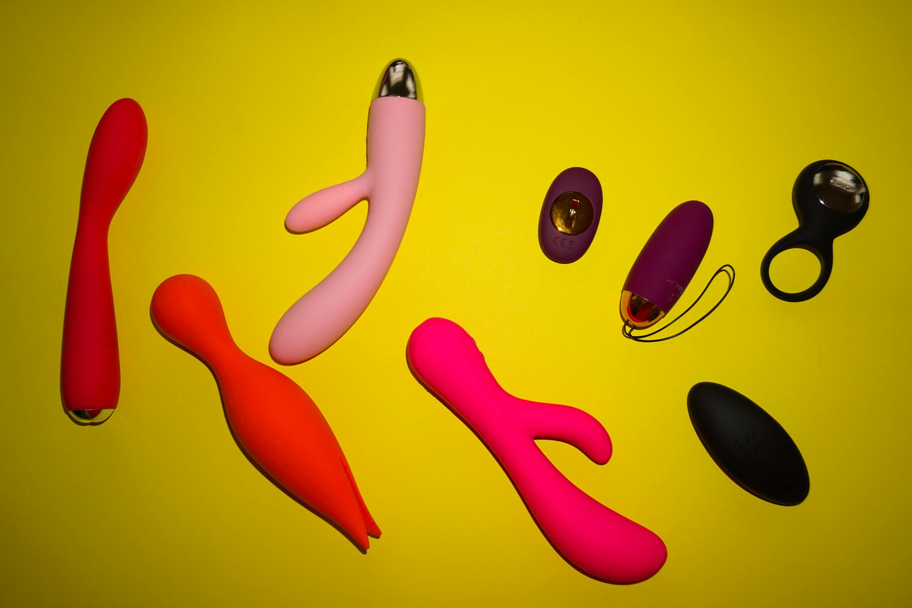 Three colorful vibrators arranged on white fabric, highlighting their smooth texture and design.